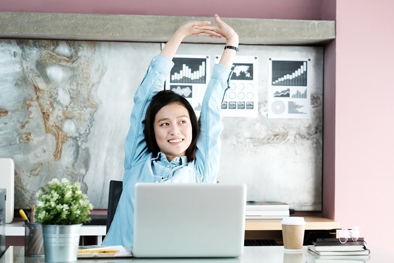 Office woman stretching body for relaxing while working with laptop computer at her desk, office lifestyle, business situation