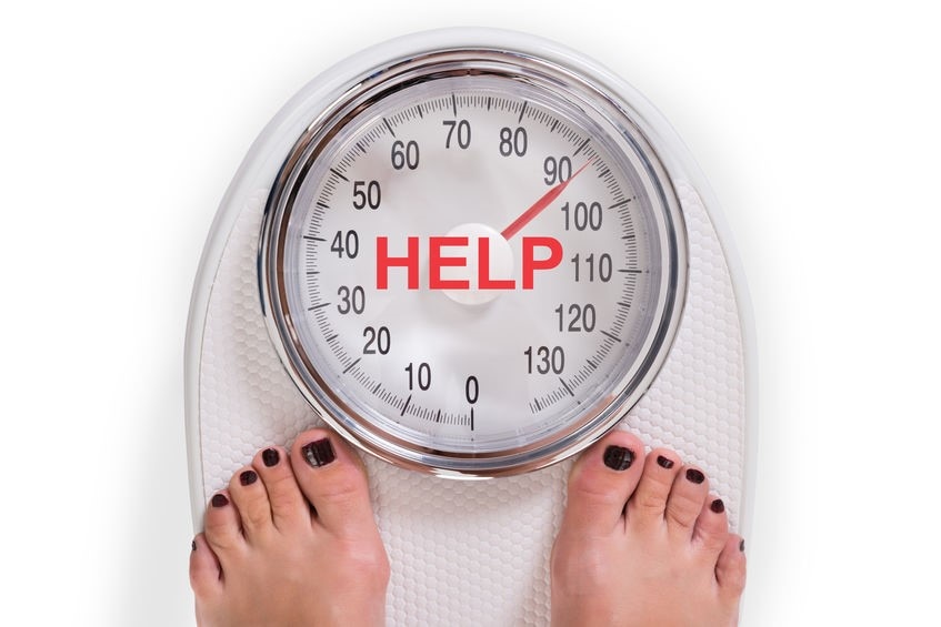 Low section of woman on weight scale with help text over white background