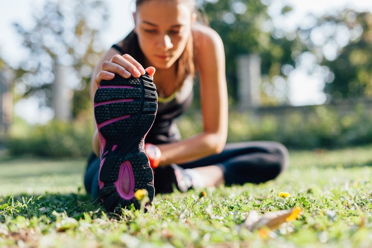 Young woman doing some warm-up exercises before running.