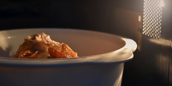 Look inside the microwave food white bowl, In a warm atmosphere and empty top space for text.