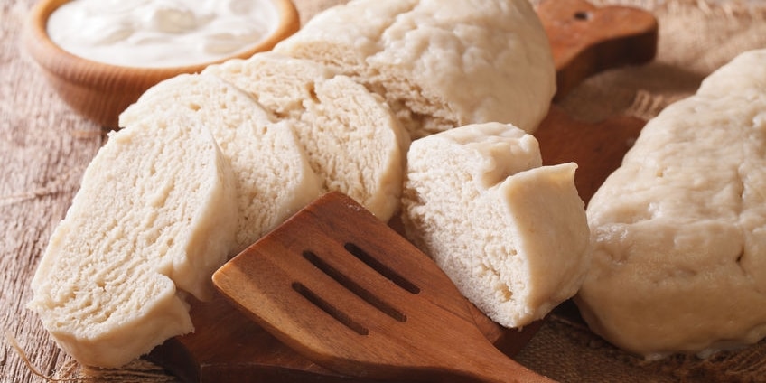 Fresh sliced yeast knedliks and sour cream close-up on the table. horizontal