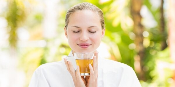 Attractive woman drinking tea in a glass at spa center